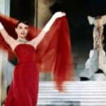 Famosissima foto dell'attrice Audrey Hepburn in Cenerentola a Parigi con il vestito rosso e il velo alzato dietro sulla scalinata