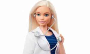 Foto con sfondo bianco di un nuovo modello di barbie con un viso più pieno e dottoressa