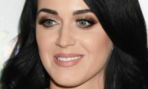 Foto in primo piano della pop star Katy Perry con un rossetto nude e l'ombretto dalle nuance champagne, i capelli sciolti e le ciglia finte, per una serata elegante
