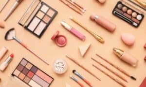 raffigurazione di vari cosmetici sparsi su uno sfondo beige chiaro