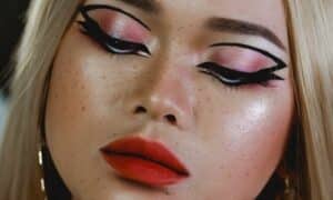Primo piano di una ragazza con un ombretto rosa shimmer e una linea di eyeliner che dalla rima delle ciglia superiori continua fino alla piega tra la palpebra mobile e fissa