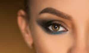 occhio in primo piano con esempio di smokey eyes colorato. Gli ombretti utilizzati sono il bianco perla sull'angolo dell'occhio, il marrone, il nero e il celeste in basso