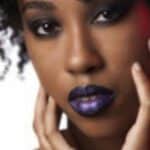Primo piano di una modella con make-up gotico con il rossetto nero e viola