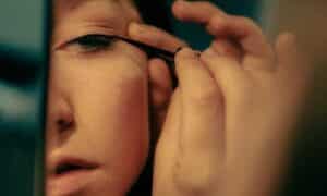 Donna utilizza un pennellino di precisione per eyeliner per fare una prima riga molto fina e precisa