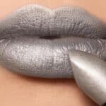 Foto di labbra truccate di grigio con poggiato il rossetto utilizzato