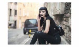 Foto di una ragazza vestita e truccata in stile goth con rossetto nero e makeup gothic