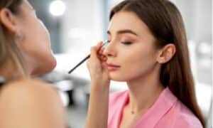 Truccatrice passa un ombretto del colore giusto per l'armocromia della modella