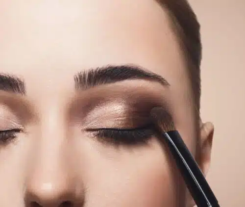 Donna che applica il trucco agli occhi per un look glamour