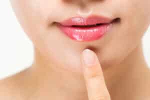 Labbra femminili con il gloss per un trucco nude
