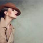 foto di una donna con cappello, di lato con un trucco labbra e occhi marsala