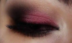 immagine in primo piano di una palpebra chiusa con un trucco marsala sfumato nero sull'esterno