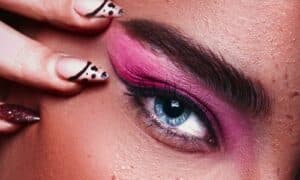In primo piano un trucco occhi dalle tonalità fucsia che si sfumano su tutta la palpebra