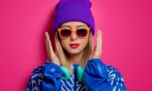 Foto di una ragazza vestita con colori molto accesi e con un trucco labbra rosa fluo