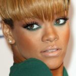 foto in primo piano di Rihanna con un trucco occhi verde sotto e oro sulla palpebra superiore