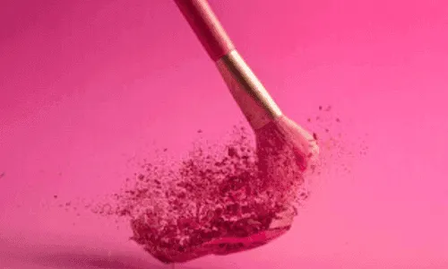 pennello per trucco su sfondo e polvere fuxia